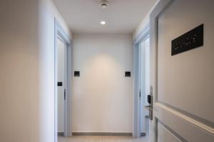a hallway with white walls and a white door at Aeifos Boutique Hotel in Imerovigli