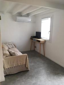 a bedroom with a bed and a desk and a window at Les planètes du port in Marseillan