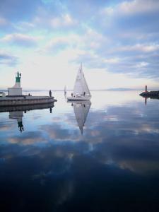 a small sail boat on the water near a dock at Les planètes du port in Marseillan +1 photo