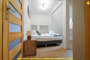 a bedroom with a bed in a room at Apartamenty Widokowe Pod Lasem in Kościelisko
