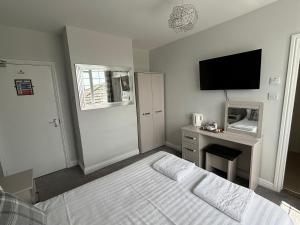 a bedroom with a bed and a desk with a television at Solway Lodge Hotel in Gretna Green