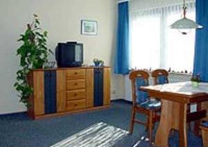 a living room with a television and a table and chairs at Haus Dornröschen in Koserow