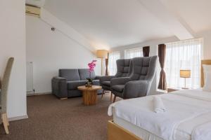 a hotel room with two chairs and a bed at Garni Hotel Biser in Kru&scaron;evac
