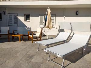 a pair of chairs and an umbrella on a patio at Mistral Guesthouse in Castro di Lecce