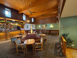 a restaurant with tables and chairs and a bar at Solway Lodge Hotel in Gretna Green