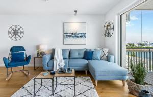 ein Wohnzimmer mit einem blauen Sofa und einem Fenster in der Unterkunft Meerleben in Olpenitz