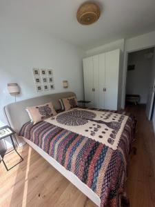 a bedroom with a large bed with a blanket on it at Wunderschönes Apartment Soul Space mit Seeblick im Marina Resort Bad Saarow in Bad Saarow