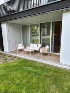 a patio with two chairs and a table on a house at Wunderschönes Apartment Soul Space mit Seeblick im Marina Resort Bad Saarow in Bad Saarow