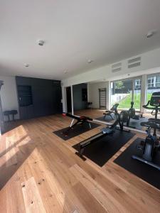 a gym with several treadmills and exercise bikes at Wunderschönes Apartment Soul Space mit Seeblick im Marina Resort Bad Saarow in Bad Saarow