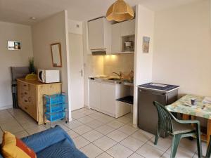 kuchnia z kanapą i stołem w pokoju w obiekcie Appartement avec piscine et parking, proche des commerces - FR-1-387-189 w mieście Marseillan