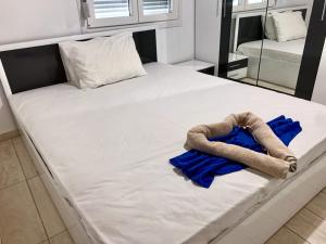 un grande letto bianco con asciugamani blu sopra di Glykeraki's House a Nea Kalikratia