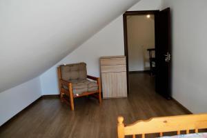 una stanza con una sedia, un comò e una porta di Glykeraki's House a Nea Kalikratia Altre 14 foto