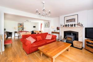 Una sala de estar con un sofá rojo y una chimenea. en Finest Retreats - Riversdale Lodge, en Symonds Yat