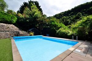 una piscina en medio de un patio con árboles en Finest Retreats - Riversdale Lodge, en Symonds Yat