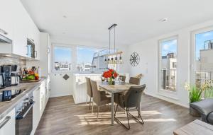 une cuisine et une salle à manger avec une table et des chaises dans l'établissement Möwennest, à Olpenitz