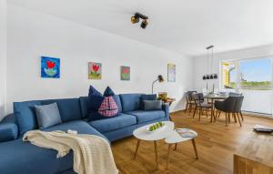 ein Wohnzimmer mit einem blauen Sofa und einem Tisch in der Unterkunft Strandnelke in Olpenitz