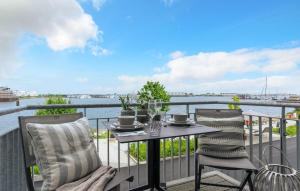 een tafel en stoelen op een balkon met uitzicht op het water bij Take Five in Olpenitz