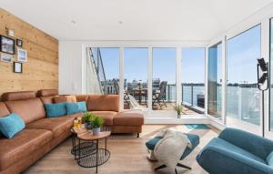 a living room with a brown couch and blue chairs at Navia in Olpenitz +21 photos