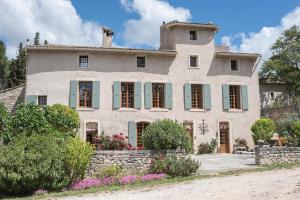 a large stone house with green shutters at Domaine de Saint Pons in Villars