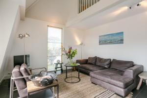 a living room with a couch and a table at OUD Duynvallei in Schoorl