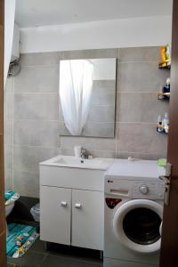 un bagno con lavatrice e lavandino di Glykeraki's House a Nea Kalikratia