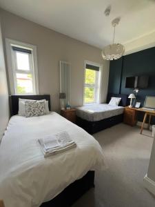 a bedroom with two beds and two windows at Hotel 50 in Bournemouth