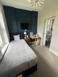 a bedroom with a bed with a blue wall at Hotel 50 in Bournemouth