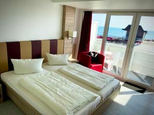 a hotel room with a bed and a view of the ocean at Seehotel in Helgoland +36 photos