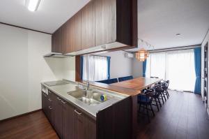 a kitchen with a sink and a counter with chairs at Nikko Holiday Home Sumica in Nikko +26 photos