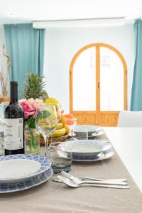 a table with plates and glasses and a bottle of wine at Grand Villa Valencia- large groups-8 min to Center by Metro in Valencia