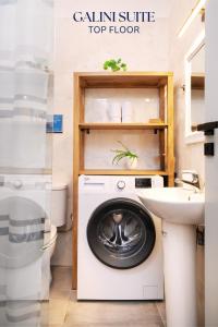 a washing machine in a bathroom next to a sink at Smyrni Rethymno Suites in Rethymno Town