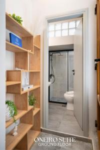 a bathroom with a glass door leading to a toilet at Smyrni Rethymno Suites in Rethymno Town