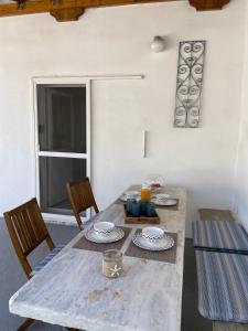 ein Esstisch mit zwei Stühlen und ein Fenster in der Unterkunft Lefakis cottage in Órmos + 14 Fotos