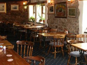 a restaurant with wooden tables and chairs in a room at King's Head Inn in Llangennith