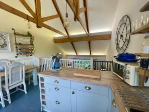a kitchen with a table and a clock on the wall at Cornwall Truro Falmouth cottage in Perranwell