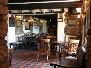 a restaurant with wooden chairs and tables in a room at King's Head Inn in Llangennith