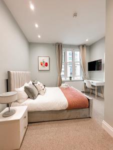 a bedroom with a bed and a desk and a television at Farringdon Rooms in London