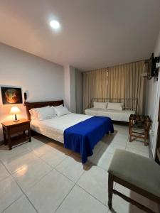 a large bedroom with two beds and a table at HOTEL ARMENIA CENTRO , TENEMOS AGUA CALIENTE y FACTURACION ELECTRONICA, Gracias in Armenia