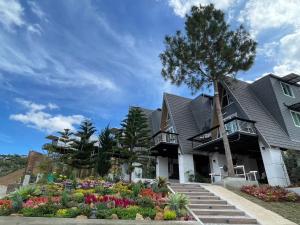a house with a garden in front of it at บ้านผูกรัก ทะเลหมอก ณ เขาค้อ in Khao Kho