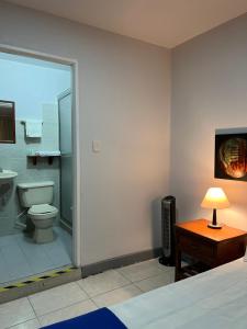 a bedroom with a bathroom with a toilet and a television at HOTEL ARMENIA CENTRO , TENEMOS AGUA CALIENTE y FACTURACION ELECTRONICA, Gracias in Armenia
