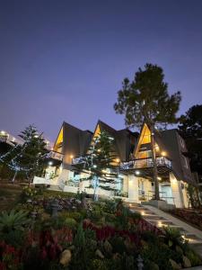 a building with a garden in front of it at night at บ้านผูกรัก ทะเลหมอก ณ เขาค้อ in Khao Kho +10 photos
