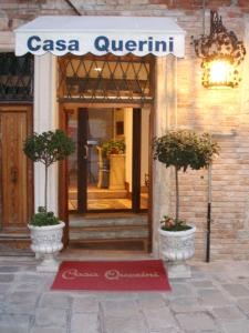 ein Gebäude mit zwei Topfpflanzen vor einer Tür in der Unterkunft Locanda Casa Querini in Venedig