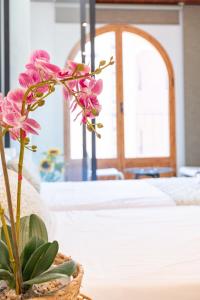 a flower in a basket on a table in a bedroom at Aparthotel Mediterráneo by NeoHotels-Centro 8 min by Metro in Valencia