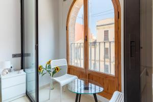 a balcony with a table and chairs and a window at Aparthotel Mediterráneo by NeoHotels-Centro 8 min by Metro in Valencia