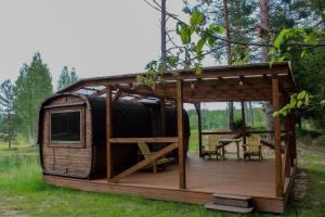 a cabin with a deck in the grass at Lubānas Mototrase in Lubāna