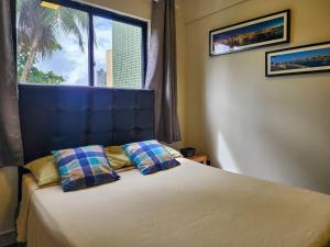 um quarto com uma cama com duas almofadas e uma janela em Prédio à beira-mar, na melhor localização do Rio Vermelho. em Salvador mais 149 fotografias
