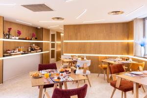 ein Restaurant mit Holzwänden, Tischen und Stühlen in der Unterkunft OVYO Hôtel in Toulouse