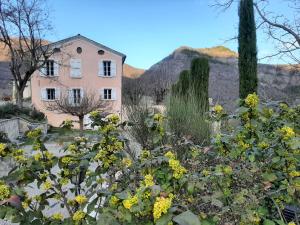 a house in front of a garden with yellow flowers at Les gîtes du château in La Robine
