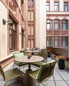 a patio with tables and chairs on a building at GRONERS Leipzig City Center in Leipzig