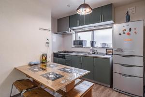 a kitchen with a table and a refrigerator at 易居の宿 in Osaka
